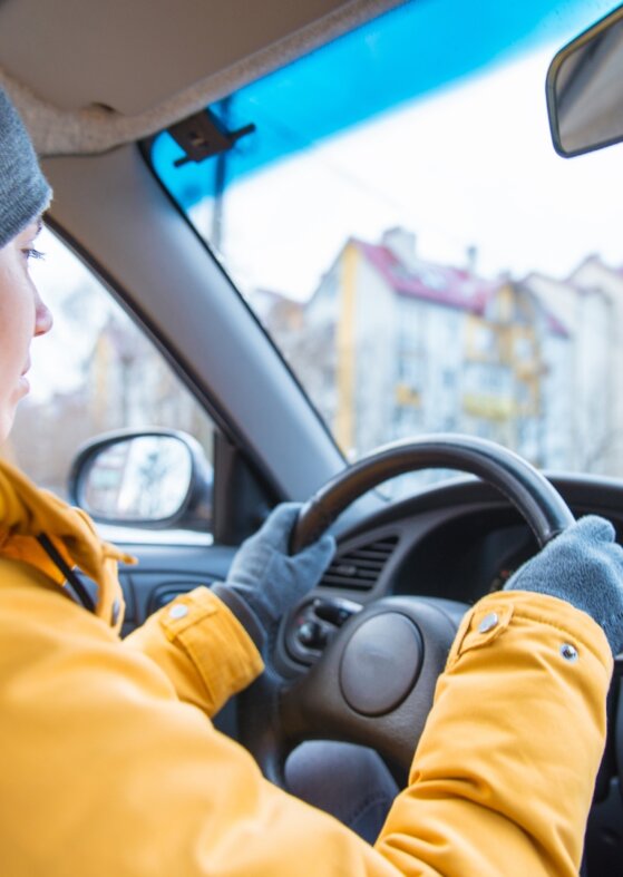 Young woman learning to drive in winter conditions